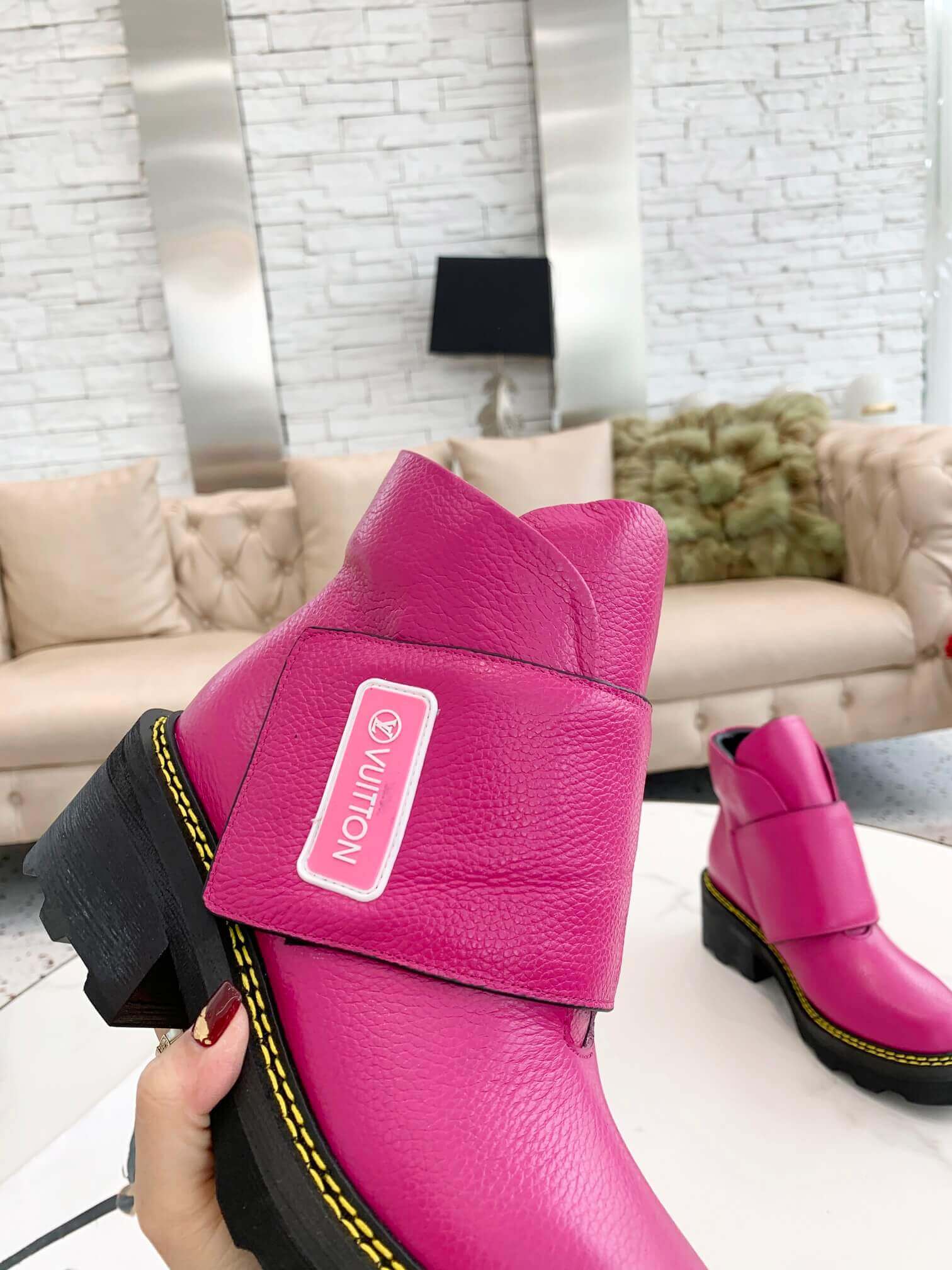 a pair of Louis Vuitton Wonderland Flat Ranger Boots in Pink Leather on a table