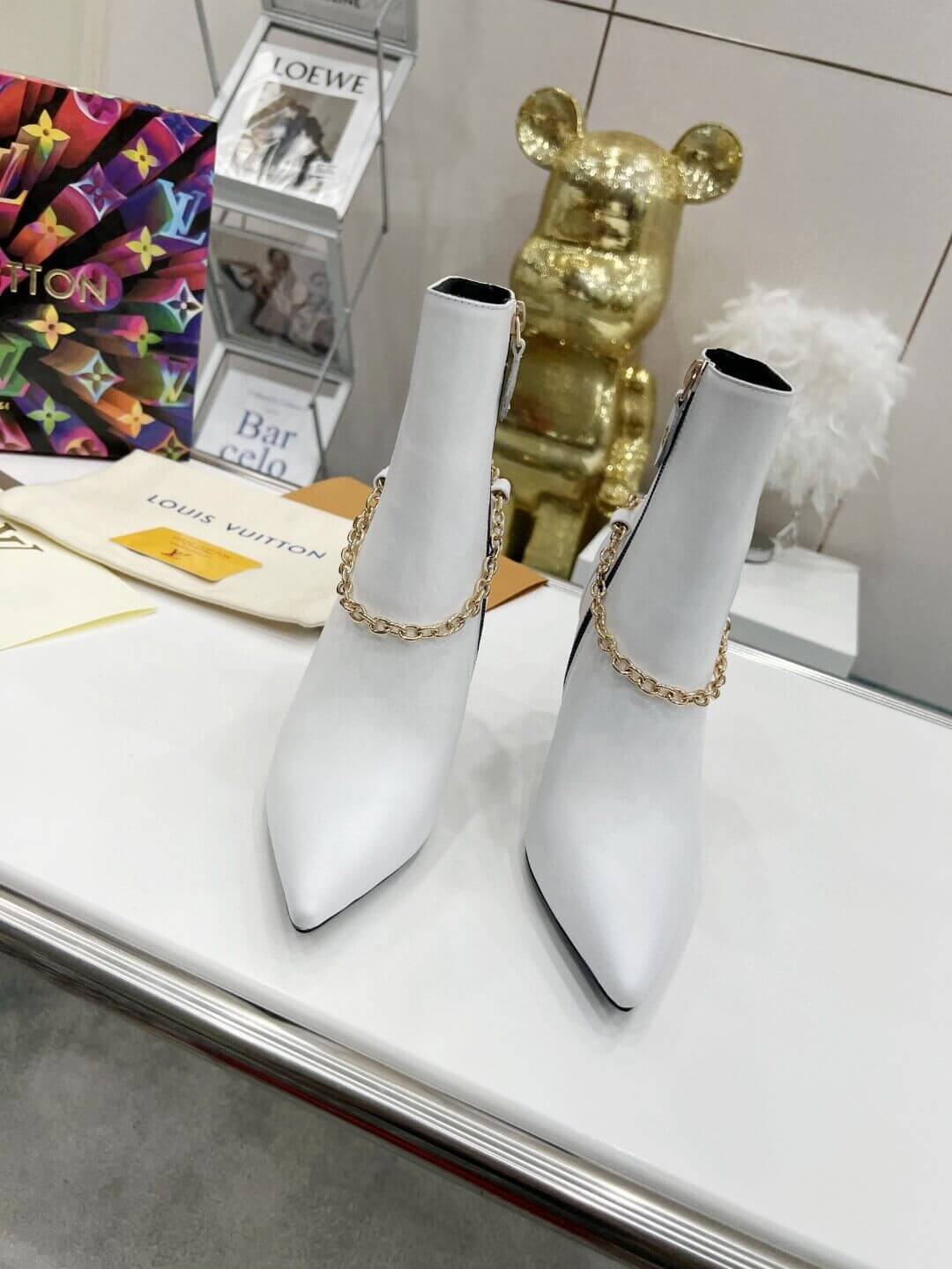 a pair of Louis Vuitton Mansion Chain Ankle Boots In White