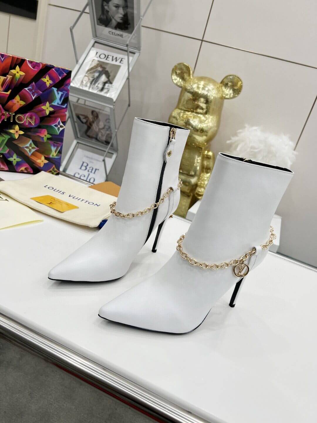 a pair of Louis Vuitton Mansion Chain Ankle Boots In White