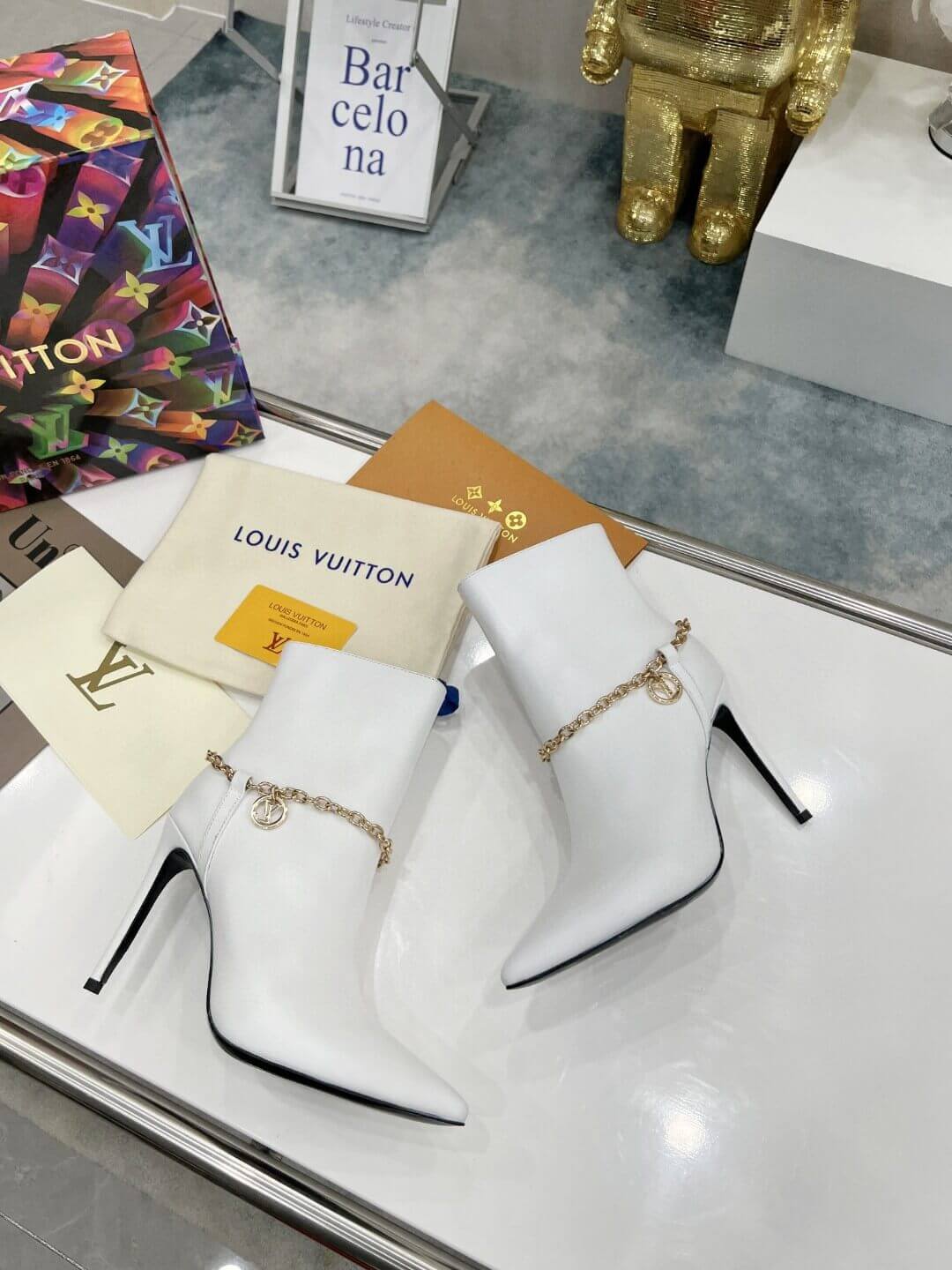a pair of Louis Vuitton Mansion Chain Ankle Boots In White