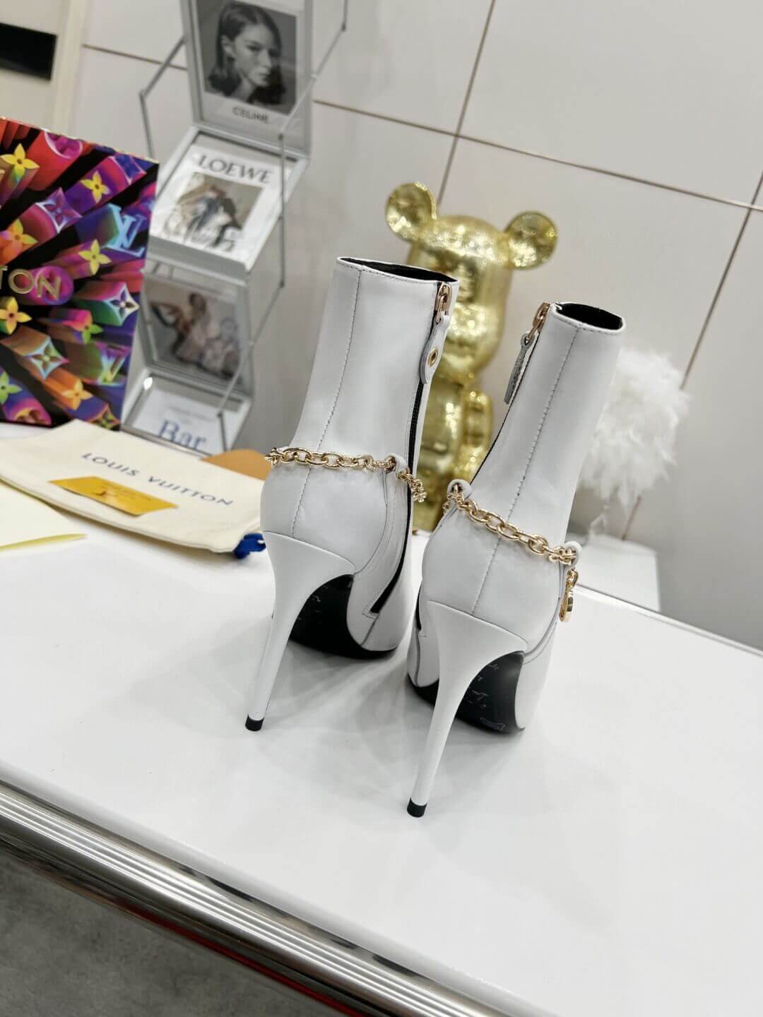 a pair of Louis Vuitton Mansion Chain Ankle Boots In White