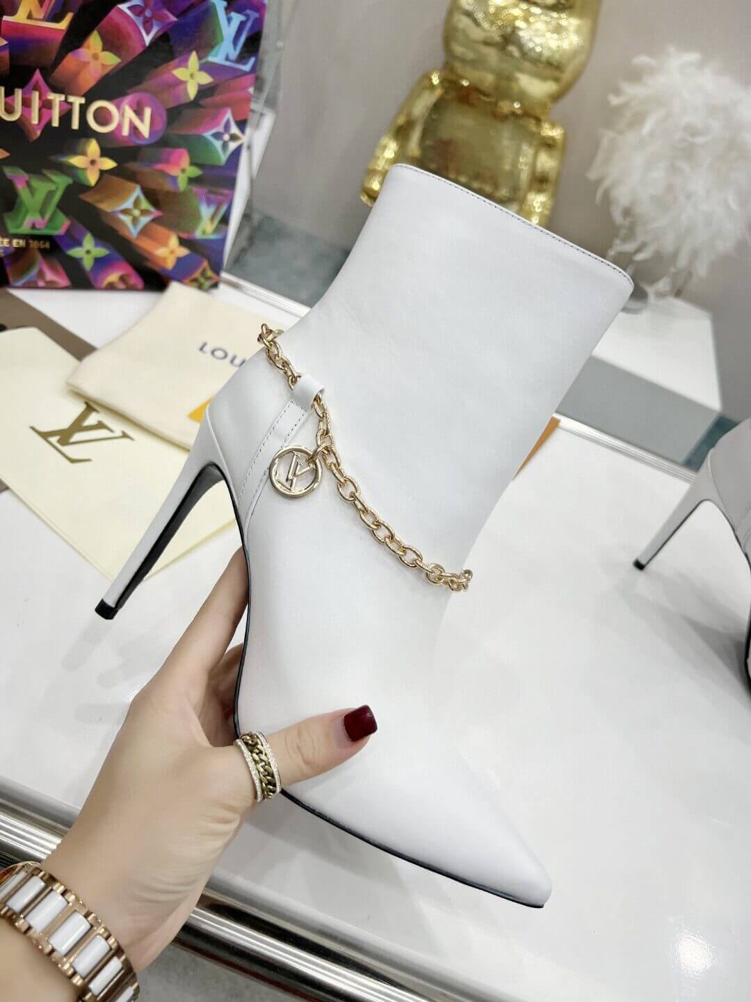 a pair of Louis Vuitton Mansion Chain Ankle Boots In White