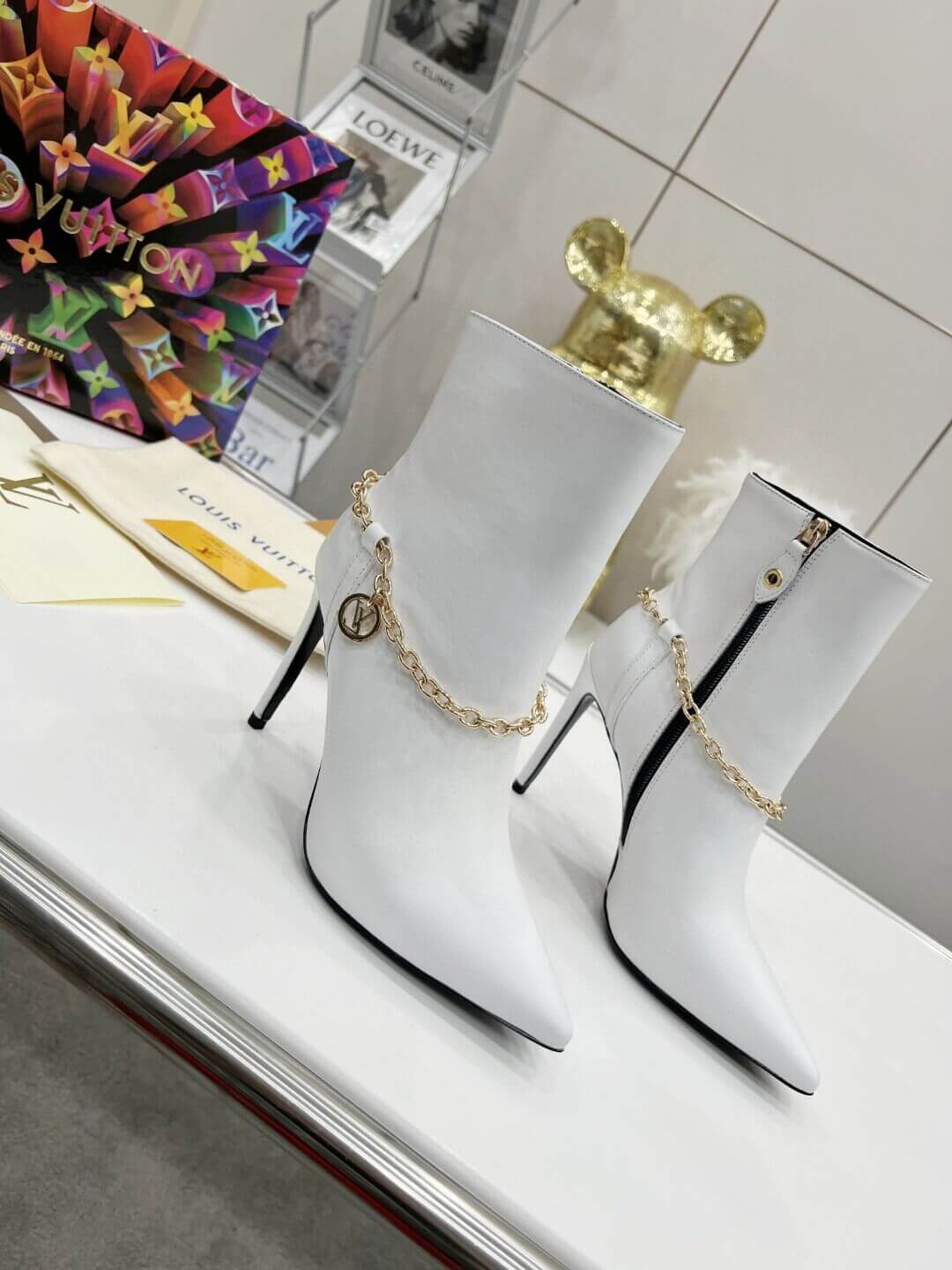 a pair of Louis Vuitton Mansion Chain Ankle Boots In White
