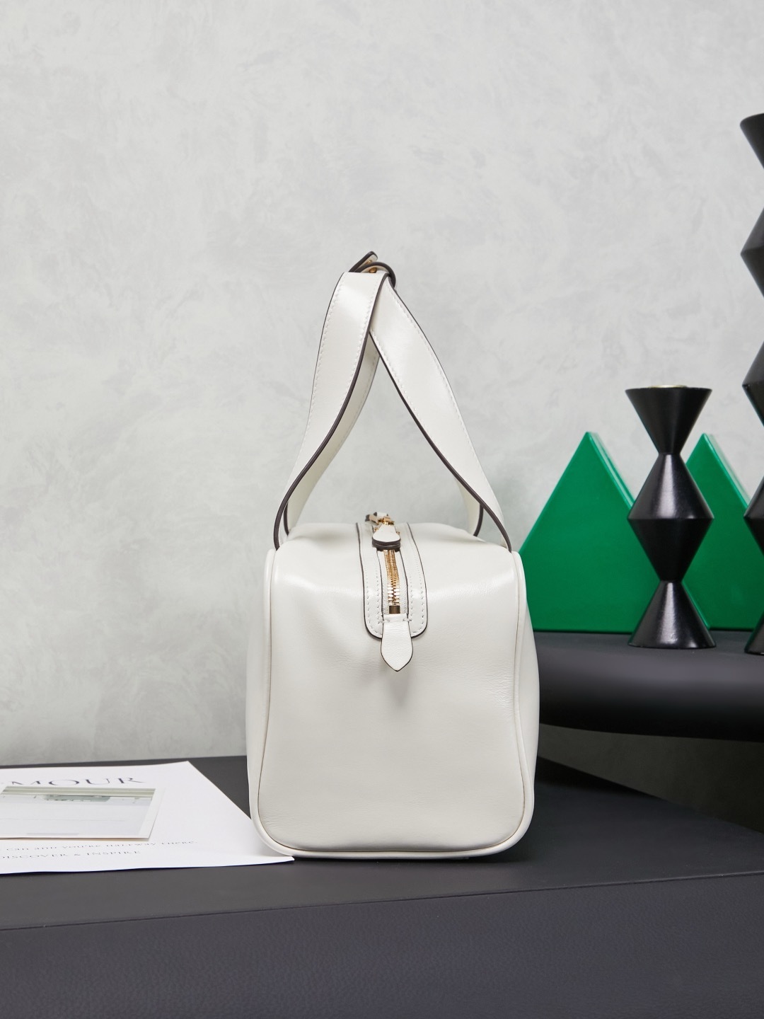white Miu Miu leather Boston bag with embossed logo and dual top handles.