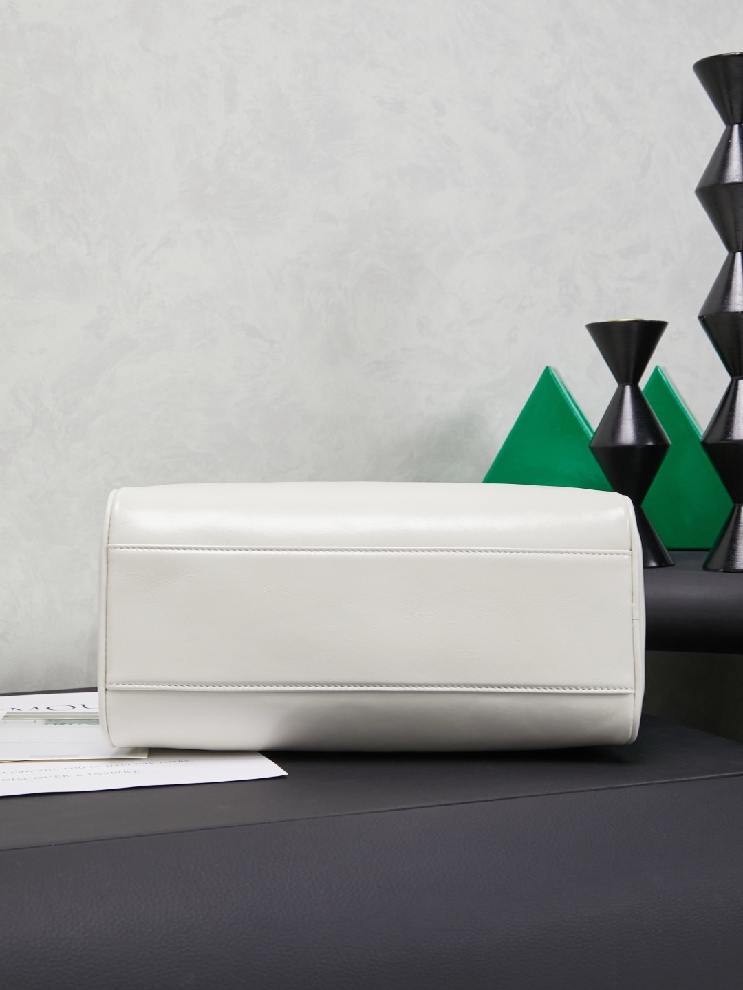 white Miu Miu leather Boston bag with embossed logo and dual top handles.