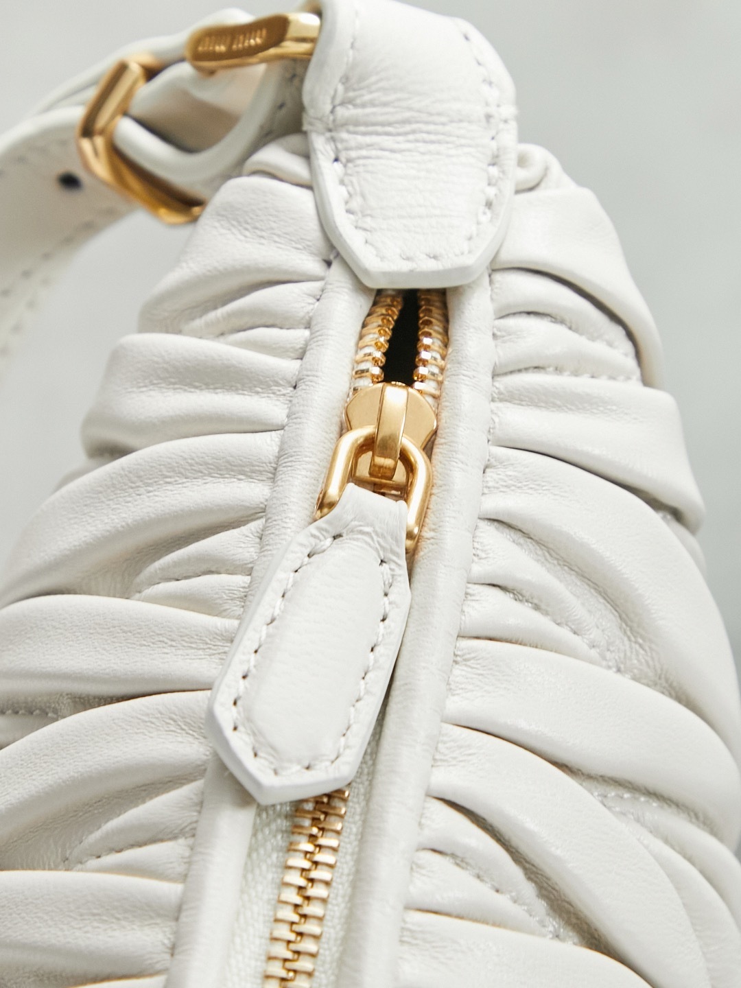 Miu Miu White Matelassé Leather Mini Shoulder Bag with gold-tone hardware and adjustable strap.