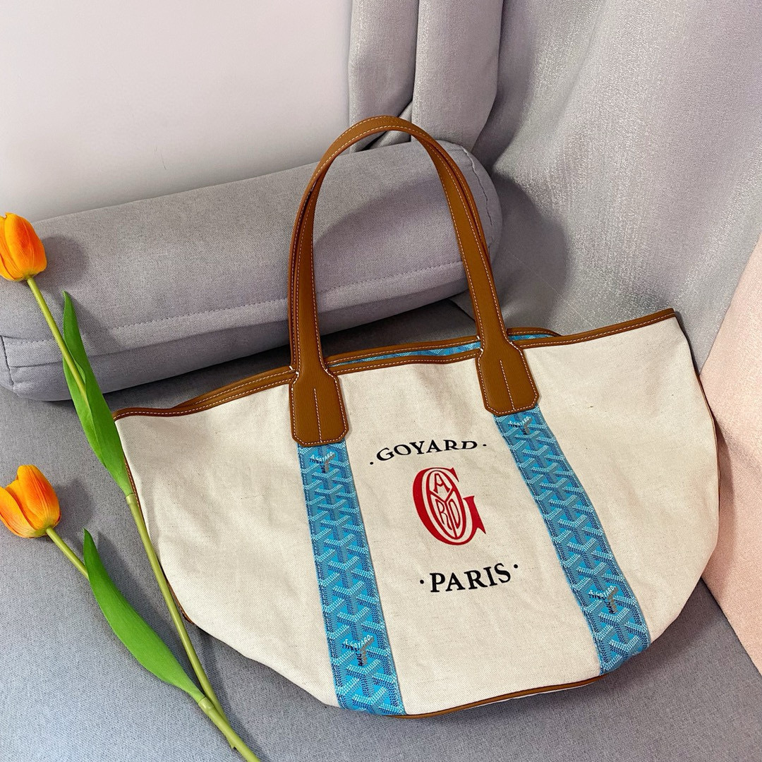 Goyard Belharra Tote in natural canvas with blue Goyardine bands and tan leather handles.