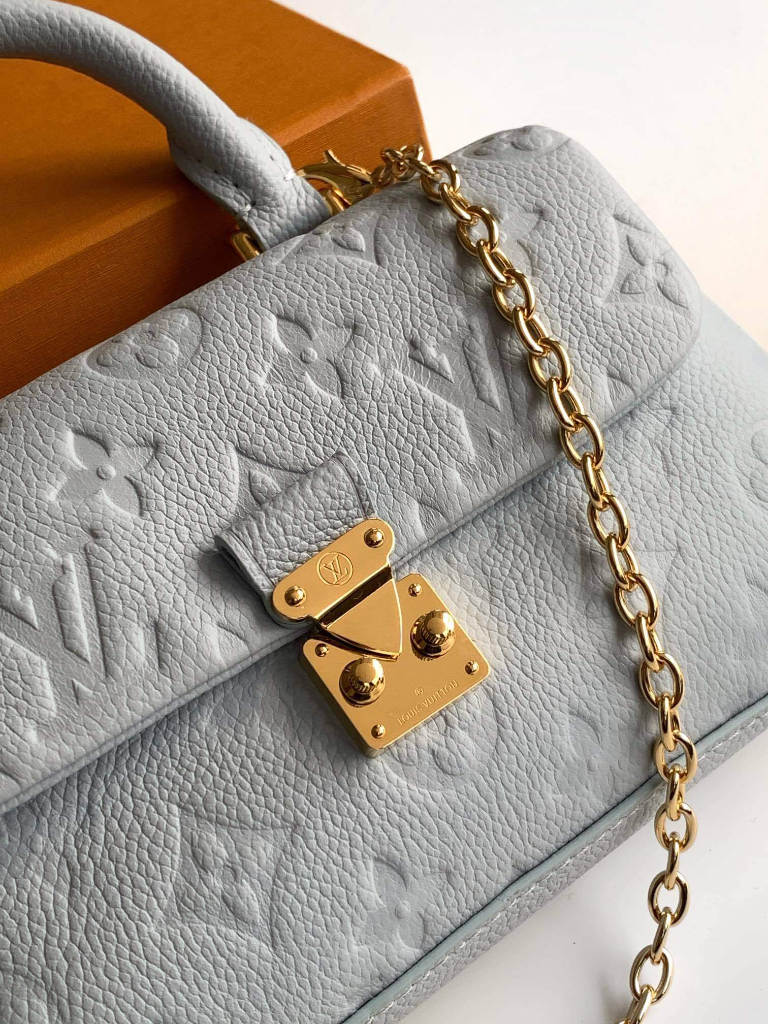 Louis Vuitton Monogram Empreinte Leather Micro Metis Light Blue Crossbody Bag with Gold Hardware and Luxury Trunk Display - Image 5