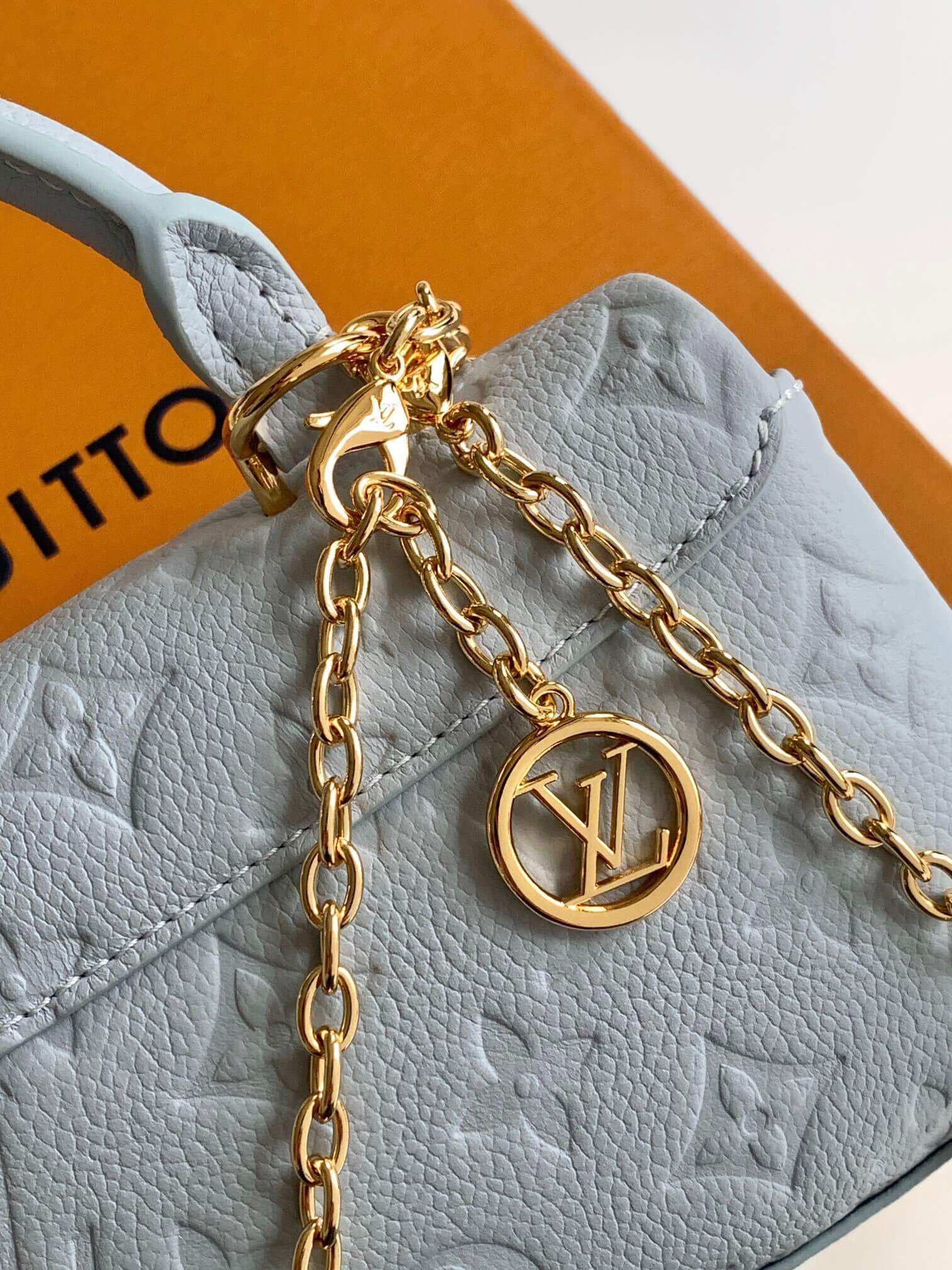 Louis Vuitton Monogram Empreinte Leather Micro Metis Light Blue Crossbody Bag with Gold Hardware and Luxury Trunk Display - Image 6