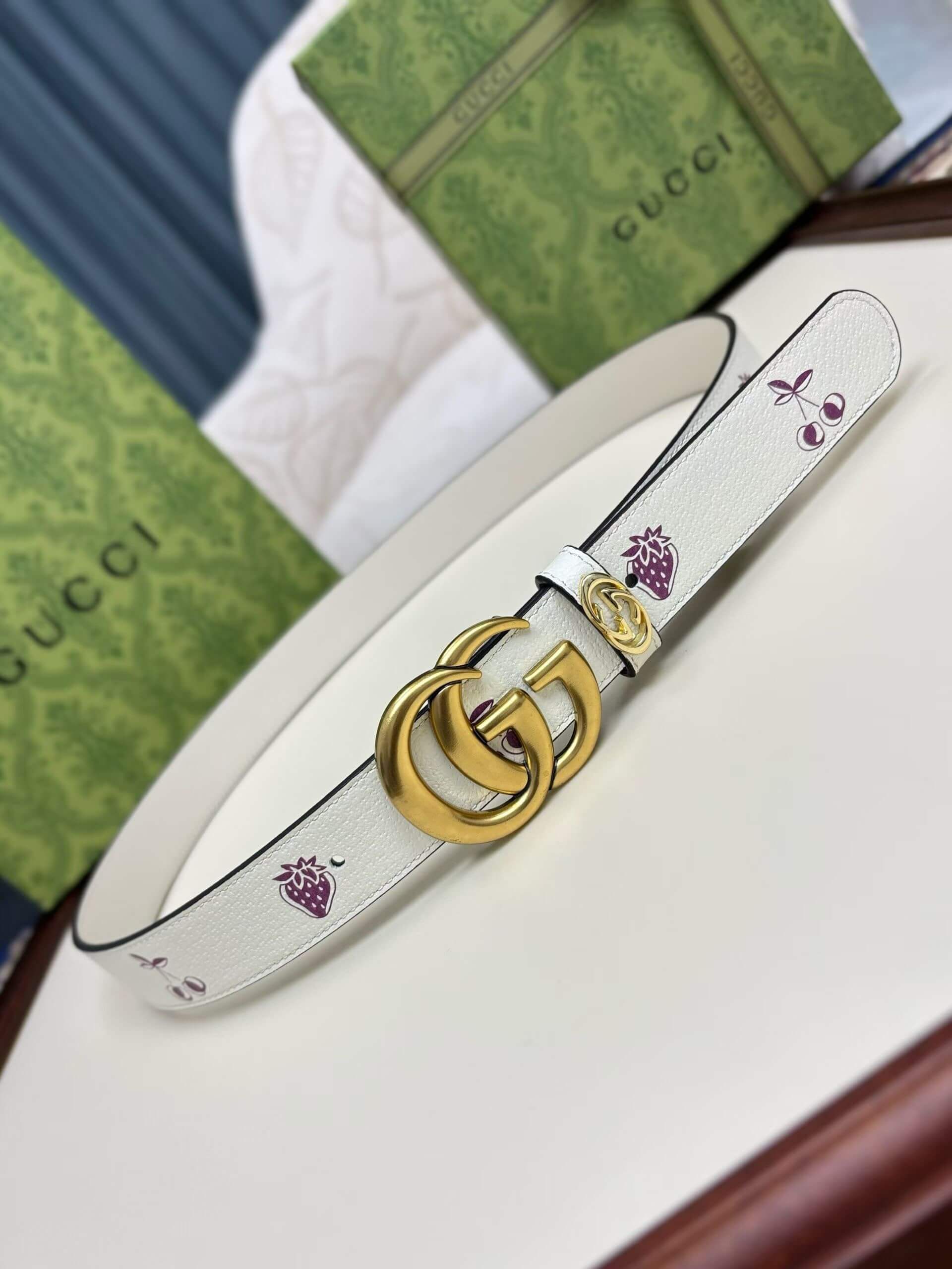 Gucci Women's White Leather Belt with Fruit Print and Gold Double G Buckle.